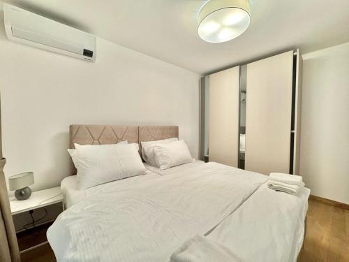 a bedroom with a large bed with white sheets at Luxury Apartments Przno in Budva