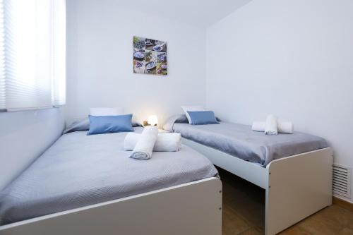 two twin beds in a room with a window at Casa Bruselas in Cambrils