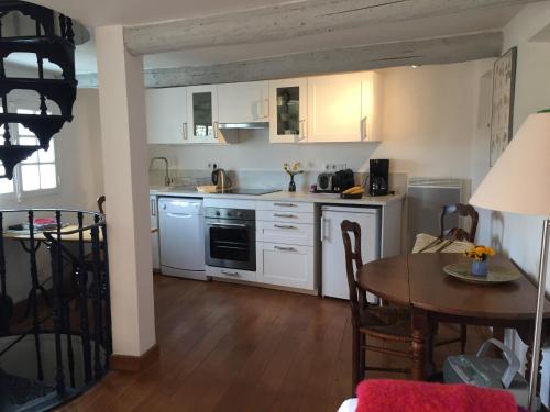 - une cuisine avec des placards blancs et une table à manger dans l'établissement Campanina, à Bonnieux