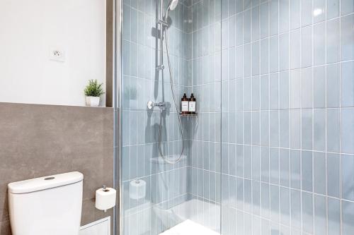 une salle de bain avec douche aux carreaux bleus dans l'établissement Eiffel residence Augustin, à Paris