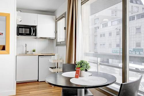 - une cuisine et une table dans une petite pièce dans l'établissement Eiffel residence Augustin, à Paris