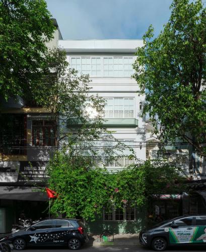 a white building with cars parked in front of it at Camellia Full House in Da Nang