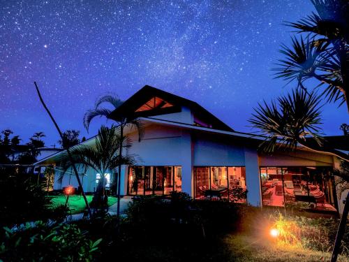 a house under a starry sky with palm trees at LiVEMAX Amms Canna Resort Villa in Ginoza