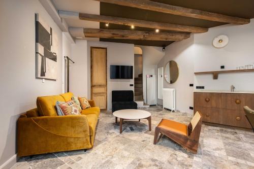 un salon avec un canapé jaune et une table dans l'établissement CMG Amazing Duplex 3BR 6P Le Marais, à Paris