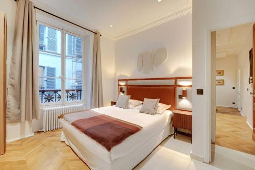 une chambre avec un grand lit et une grande fenêtre dans l'établissement Charm and Elegance for 8P-3BR - Grands Boulevards, à Paris