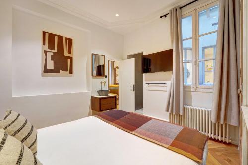 une chambre avec un lit blanc et une fenêtre dans l'établissement Charm and Elegance for 8P-3BR - Grands Boulevards, à Paris