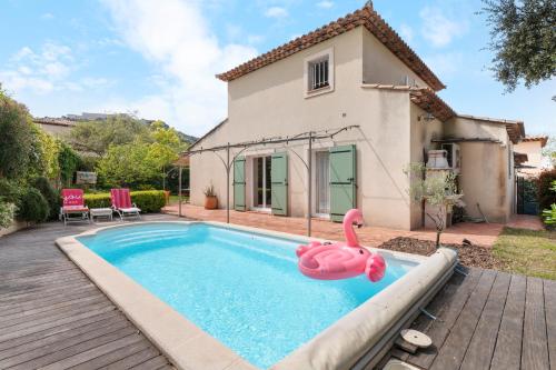 une piscine avec un cygne rose en face d'une maison dans l'établissement Jolie Villa Provençale indépendante, à Six-Fours-les-Plages