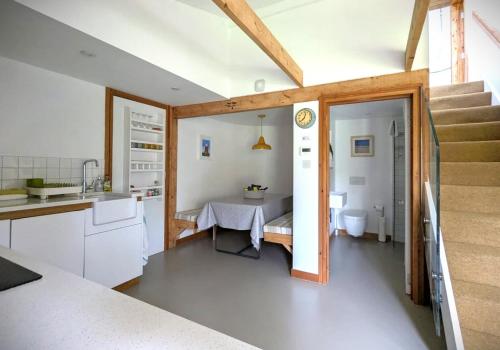 a kitchen with a sink and a table in a room at Unique & Rural Child Friendly Annexe with Large Gardens, Games & Tennis Court - Chichester Holiday Properties in Chichester