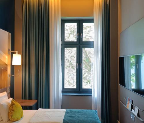 Ένα ή περισσότερα κρεβάτια σε δωμάτιο στο MERCURE Hotel Berlin Wittenbergplatz