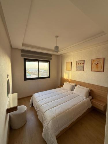 a bedroom with a large bed and a window at Appartement a zenata ain-harrouda casablanca in Mohammedia