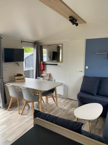 a living room with a table and a blue couch at chalet 6 personen HZ23 in Lauwersoog