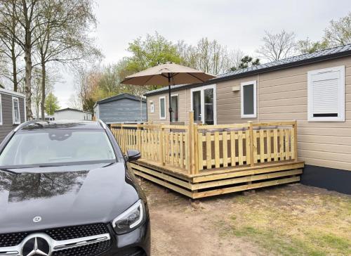 a car parked in front of a house with an umbrella at chalet 6 personen HZ23 in Lauwersoog