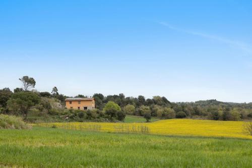 a house in the middle of a field of yellow flowers at La Serreta in Gironella