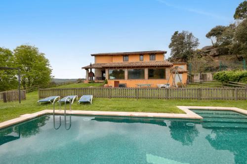 a house with a swimming pool in front of a house at La Serreta in Gironella