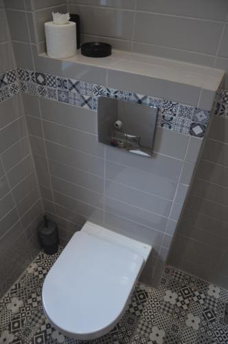a bathroom with a white toilet in a tiled room at The Annexe @ Woodland in Bury