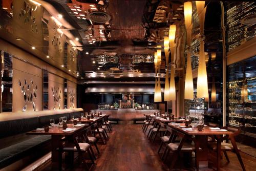 a restaurant with wooden tables and chairs and a bar at Hilton Kuala Lumpur in Kuala Lumpur