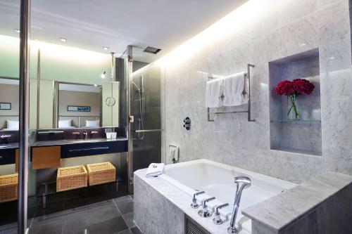 a bathroom with a bath tub and a sink at Hilton Kuala Lumpur in Kuala Lumpur