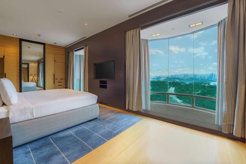 a bedroom with a bed and a large window at Hilton Kuala Lumpur in Kuala Lumpur