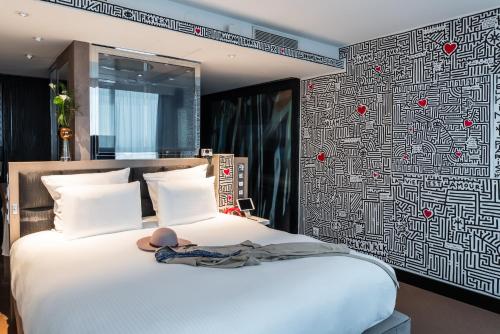 a bedroom with a bed with a black and white patterned wall at Pullman Paris Centre - Bercy in Paris