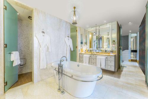 a large bathroom with a tub and a sink at Hilton Kuala Lumpur in Kuala Lumpur