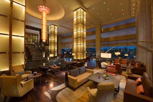 a lobby of a hotel with tables and chairs at Hilton Kuala Lumpur in Kuala Lumpur