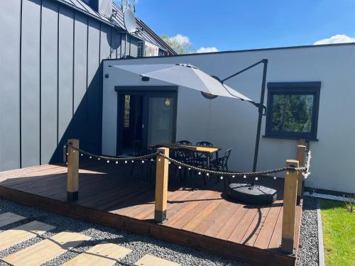 a wooden deck with a table and an umbrella at Villa Nautica in Stary Dębiec
