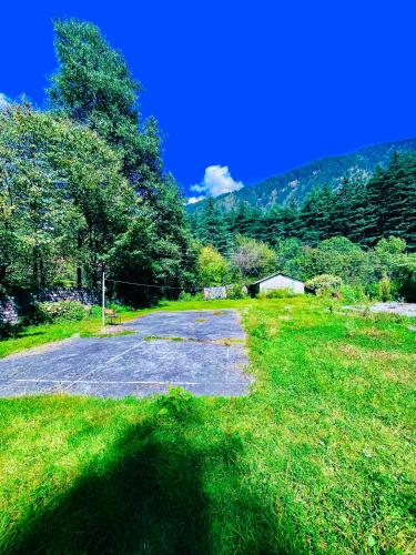 a road in the middle of a grass field at Sagar Resort - Best Selling Hotel near Mall Road Manali in Manāli