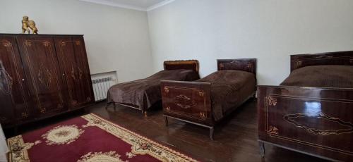 Una habitación con tres camas y muebles de madera. en Sayat-Nova Apartment Dilijan, en Dilijan