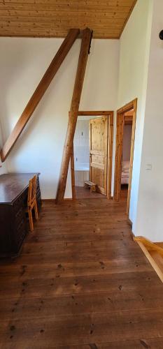 an attic room with a wooden floor and wooden beams at Ferienwohnungen Das Finkhaus in Simonsberg