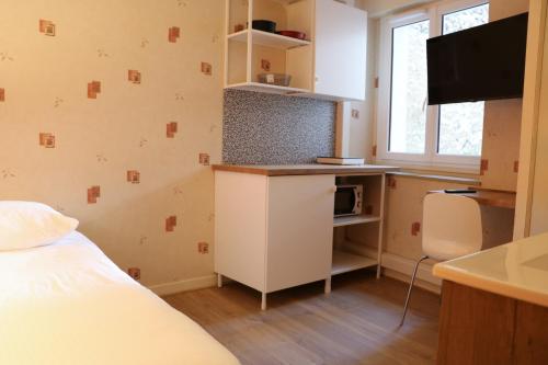 Cette chambre comprend un lit et un bureau avec un four micro-ondes. dans l'établissement Revotel - Studio & Chambre - Semaine & Mois, à Aix-les-Bains
