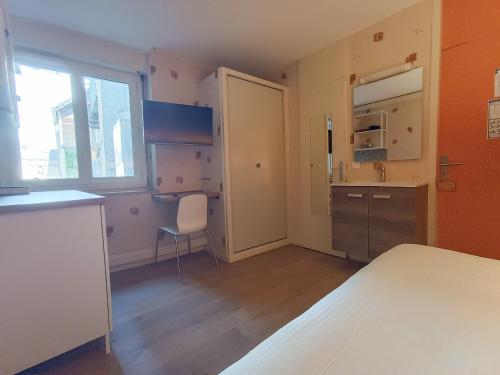 une cuisine avec une porte ouverte sur une pièce dans l'établissement Revotel - Studio & Chambre - Semaine & Mois, à Aix-les-Bains