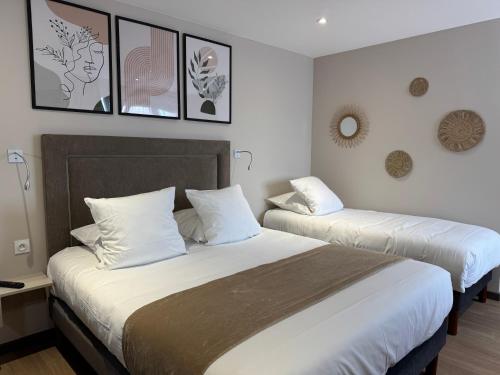 - 2 lits dans une chambre d'hôtel aux murs blancs dans l'établissement Hôtel du Commerce-restaurant au Couteau, à Nogent