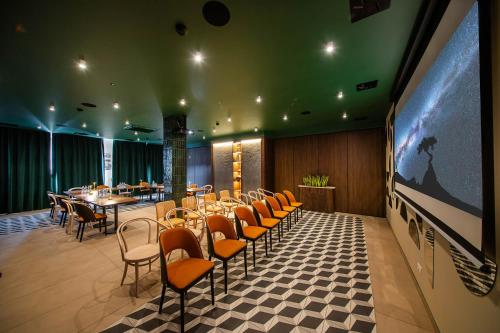 restauracja ze stołami i krzesłami oraz dużym ekranem w obiekcie Gold Hotel w mieście Złotoryja