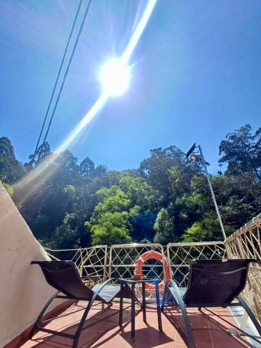 a pair of chairs sitting on a deck with the sun at Casa Mari La Moscona in Cudillero