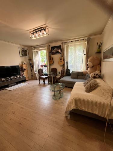 a living room with a teddy bear sitting on a bed at Beautiful 3-room, Porte Saint-Cloud, Paris in Paris
