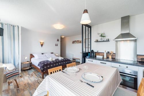 Il comprend une cuisine et une chambre avec une table et un lit. dans l'établissement L'Armorique - Proche plage avec parking, à Trébeurden