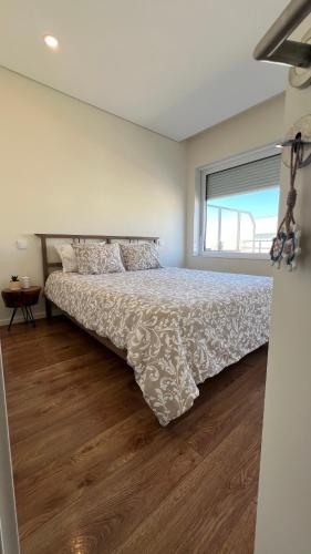 ein Schlafzimmer mit einem Bett und einem Fenster in der Unterkunft Vila Mar Guest House in Vila do Conde