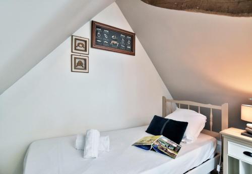 - une chambre dotée d'un lit avec une horloge murale dans l'établissement Maisonnette Les Agapanthes de Cancale 23 personne, à Cancale