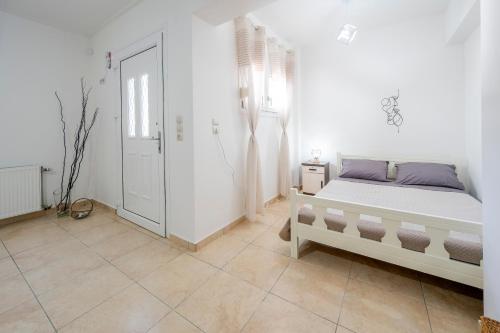 a white bedroom with a bed and a window at Acasă Comfort House in Zipárion