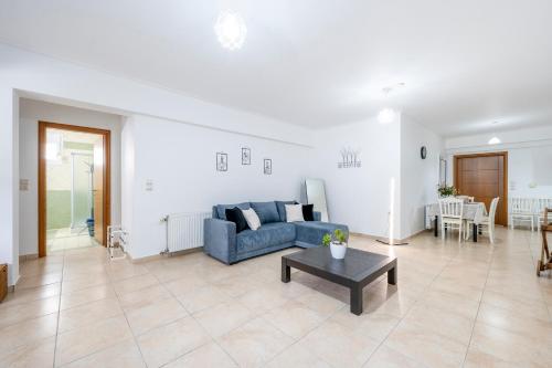 a living room with a blue couch and a table at Acasă Comfort House in Zipárion