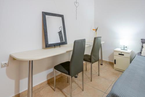 a desk with two chairs and a mirror and a bed at Acasă Comfort House in Zipárion
