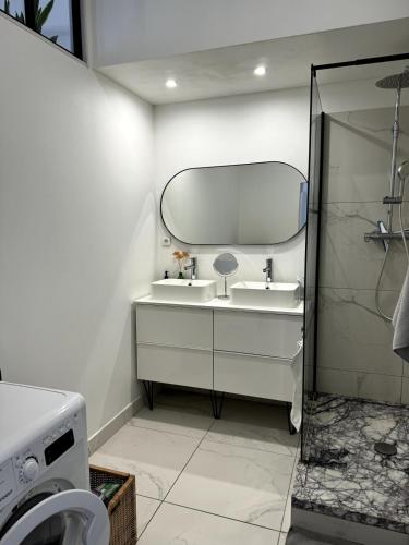 une salle de bain avec un lavabo et un miroir dans l'établissement Haussmannien - Lumière et mer, à Marseille