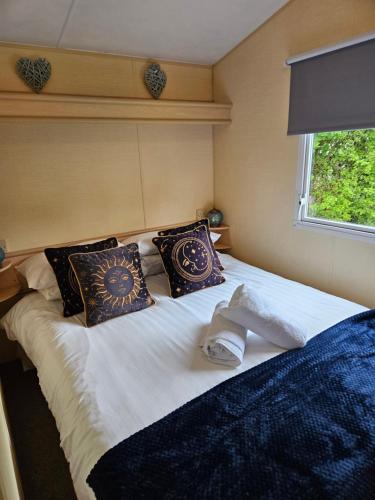 a large white bed with pillows and a window at Daisy Lodge Lilac Grove 3 in Waxholme