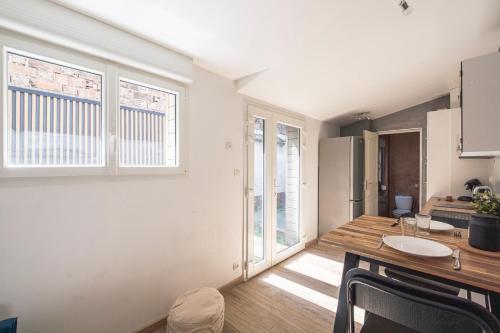 a kitchen and dining room with white walls and windows at Le Patio Champenois in Reims