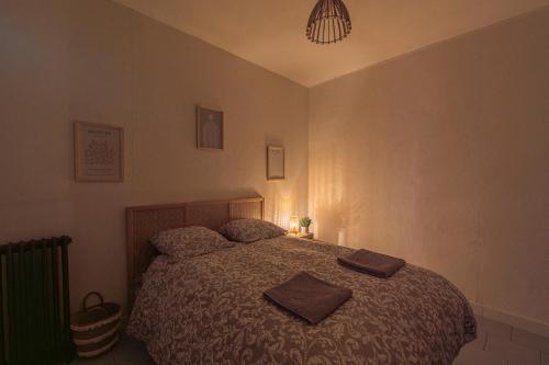 a bedroom with a bed with two towels on it at Le Patio Champenois in Reims