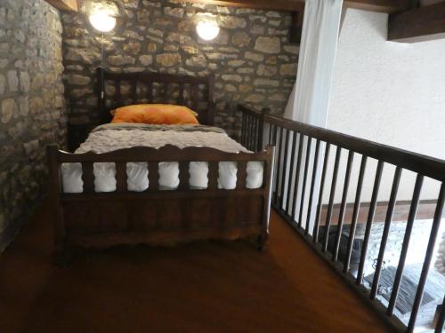 a bedroom with a bed in a stone wall at Mare Mars Chambres et table d'hotes in Mars-sur-Allier