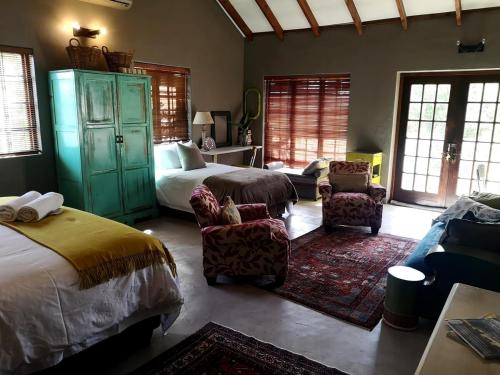 a bedroom with a bed and a bed and a couch at A cozy, artistic suburban-stay at Alice in Africa in Rooihuiskraal