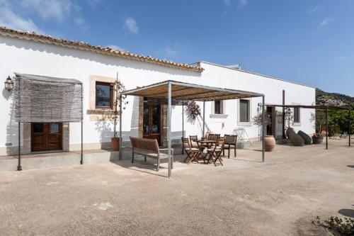 a patio with a table and chairs in front of a building at Agriturismo Alle Riserve Cavagrande in Avola