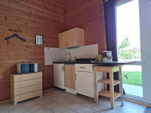 a kitchen with a counter and a table in a room at Vakantie boerderij Pepinushof - Blokhut in Maria-Hoop