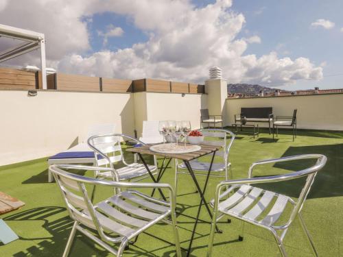 a patio with chairs and a table with wine glasses at Apartment Tramuntana by Interhome in Lloret de Mar